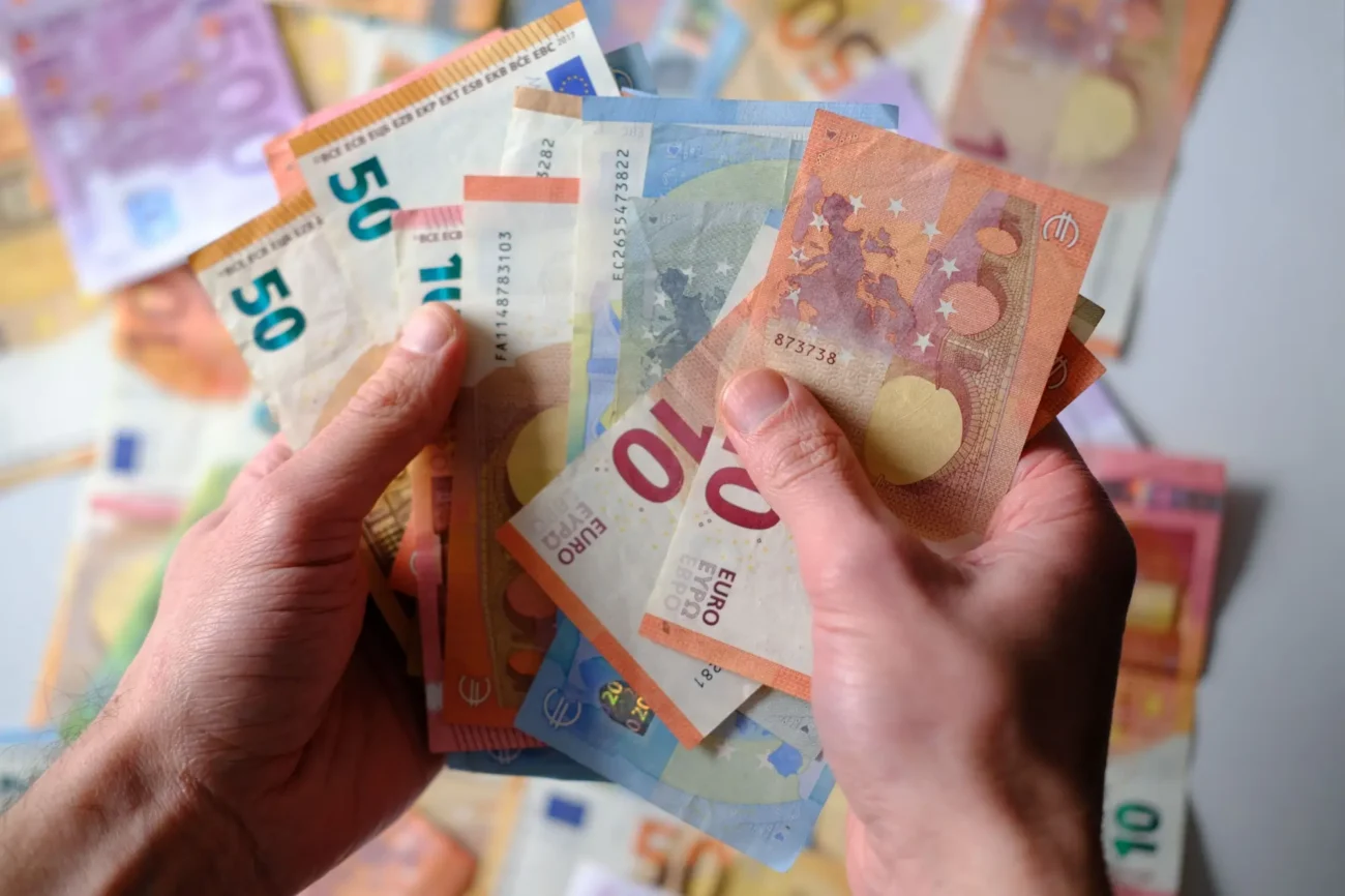 ruce které drží eurové bankovky