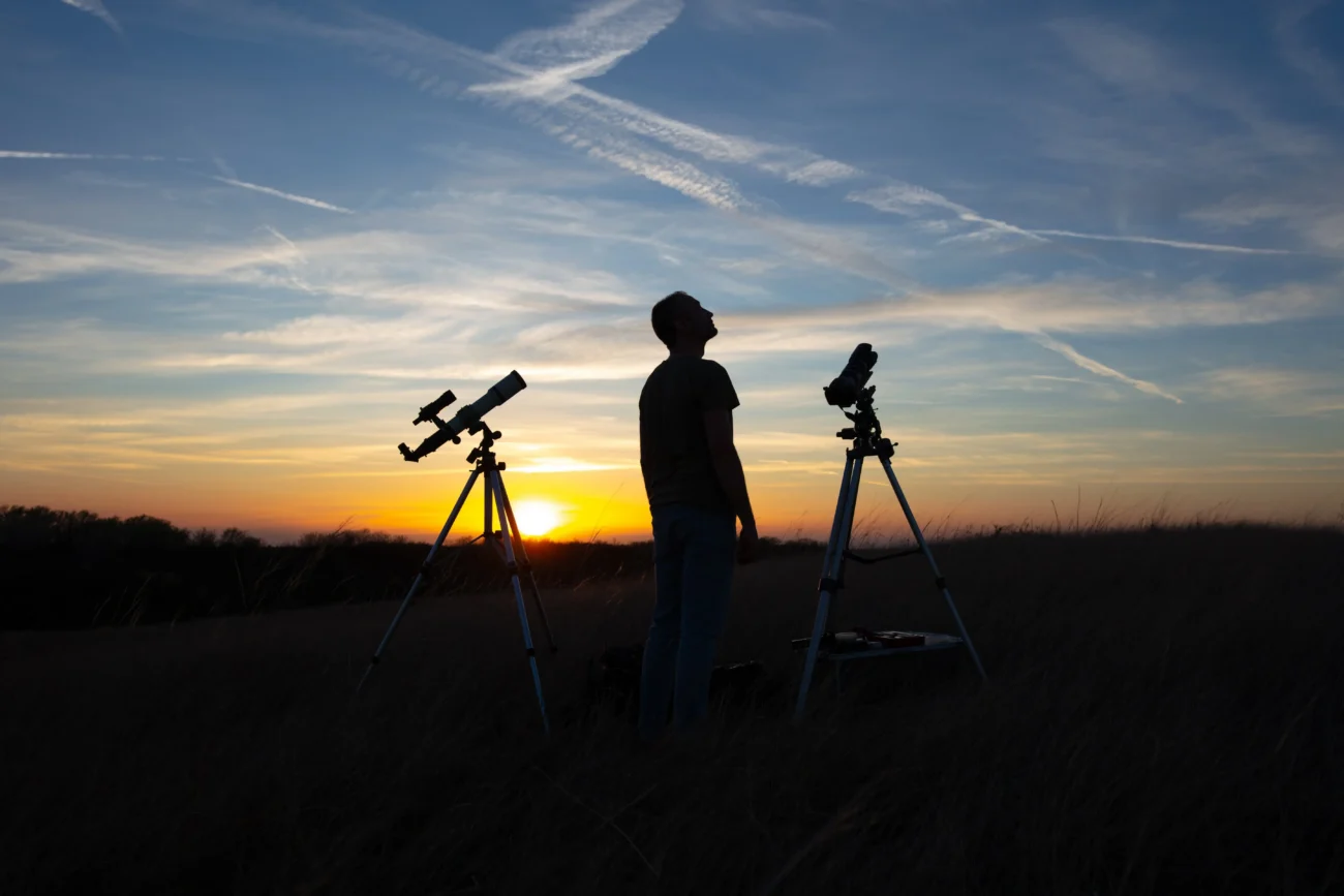 shutterstock_2473627403 1 | TVGURU.cz Muž stojí v noci na louce s astronomickým dalekohledem.