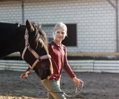 Dívka vede koně.