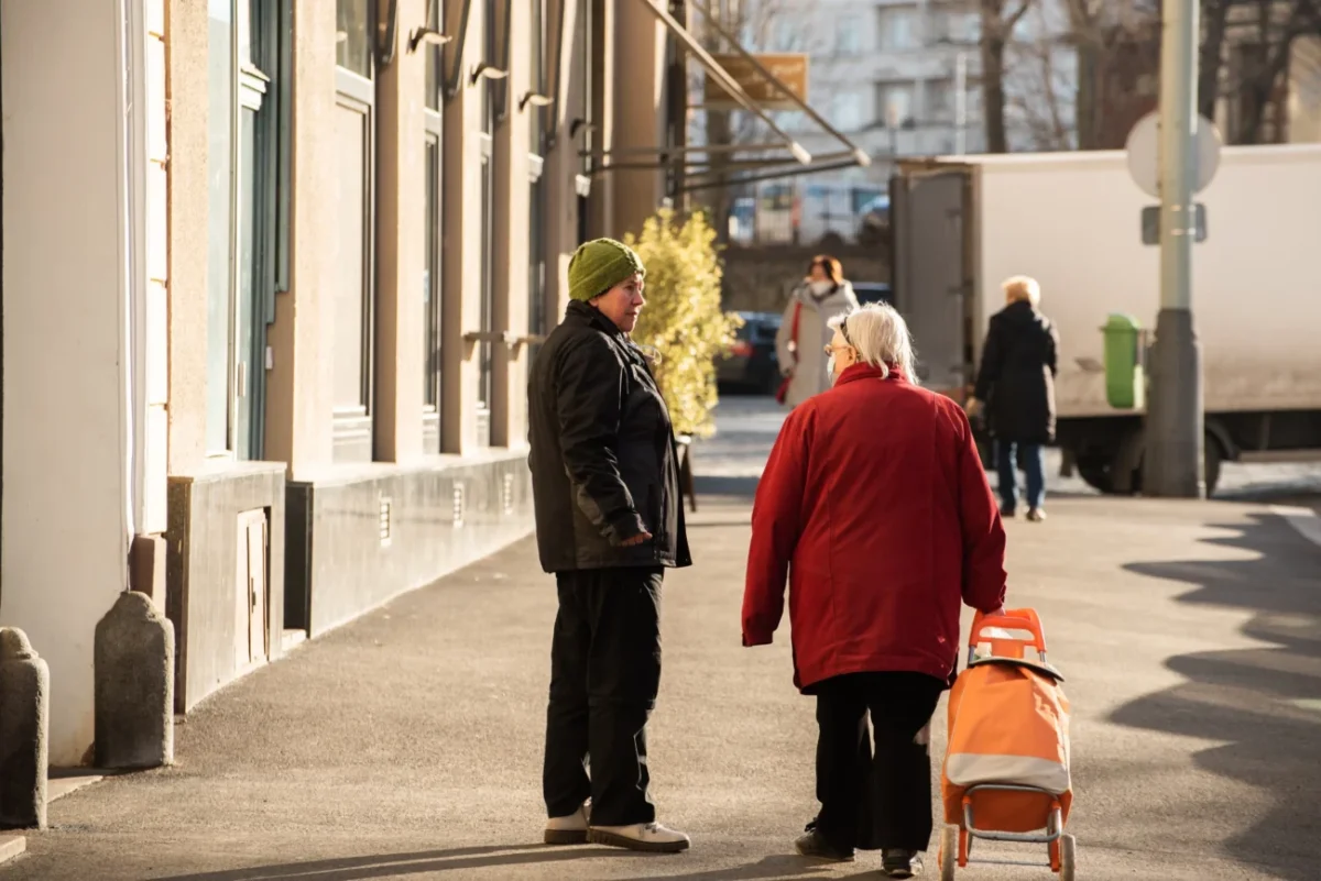 Dvě staré ženy si povídají na ulici.