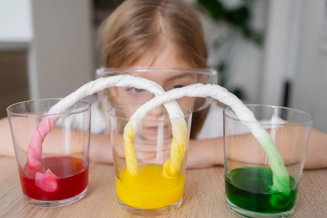Holčička dělá fyzikální experiment. 