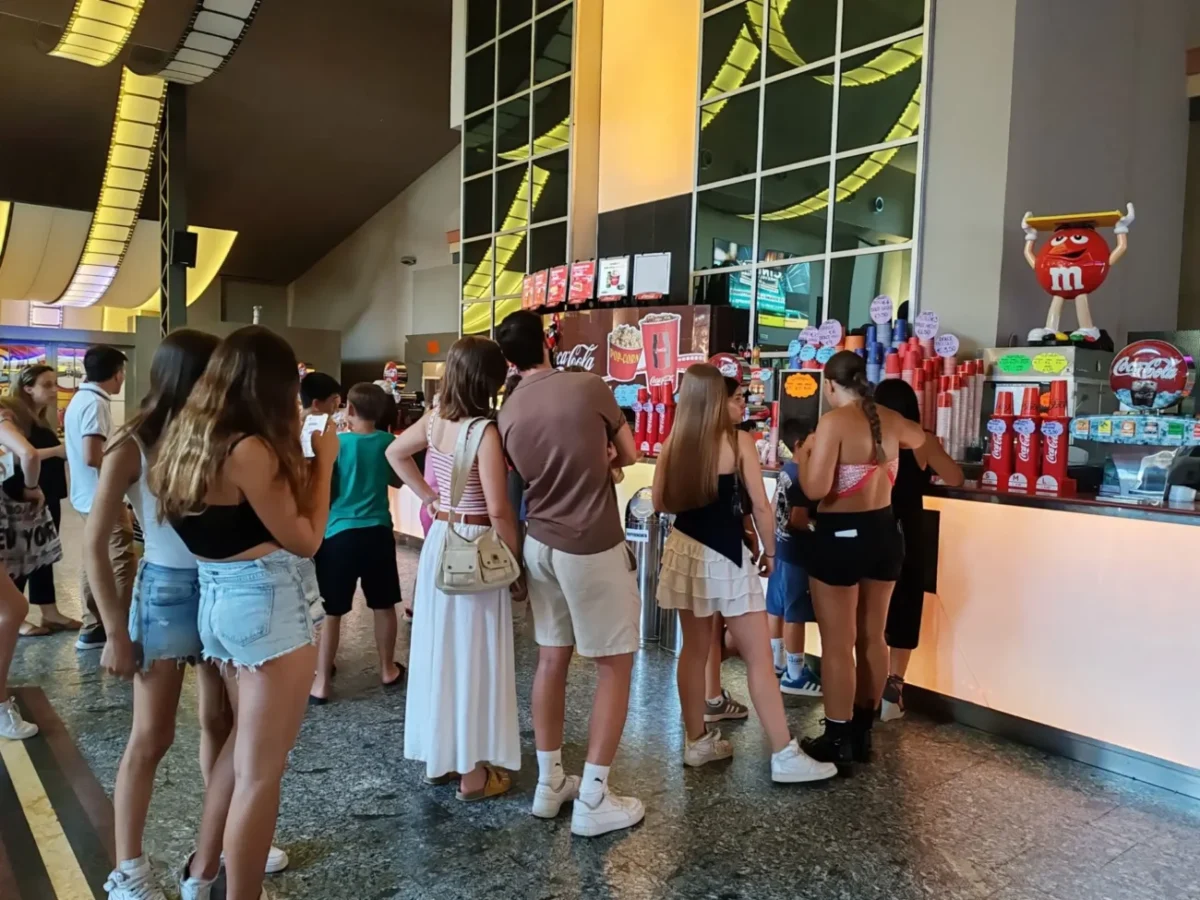 Fronta lidí stojících u pokladny v kině.