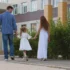 Muž s ženou drží za ruku holčičku a procházejí se venku.