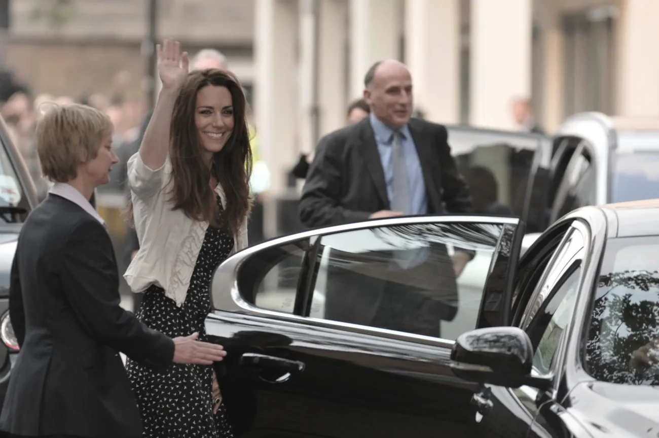 Kate Middleton se usmívá, mává a míří do auta.