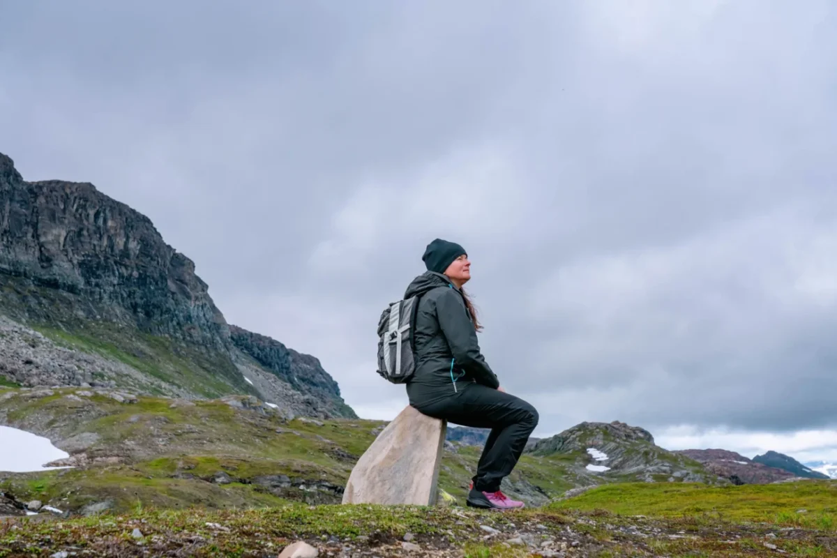 Žena sedí sama v horách.