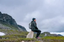 Žena sedí sama v horách.