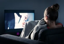 Žena se dívá na strašidelný pořad v televizi.