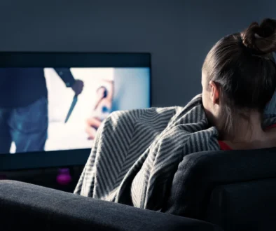 Žena se dívá na strašidelný pořad v televizi.