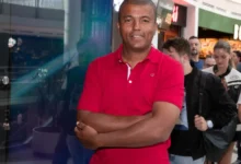 Usmívající se Rey Koranteng stojící ve frontě do kina.