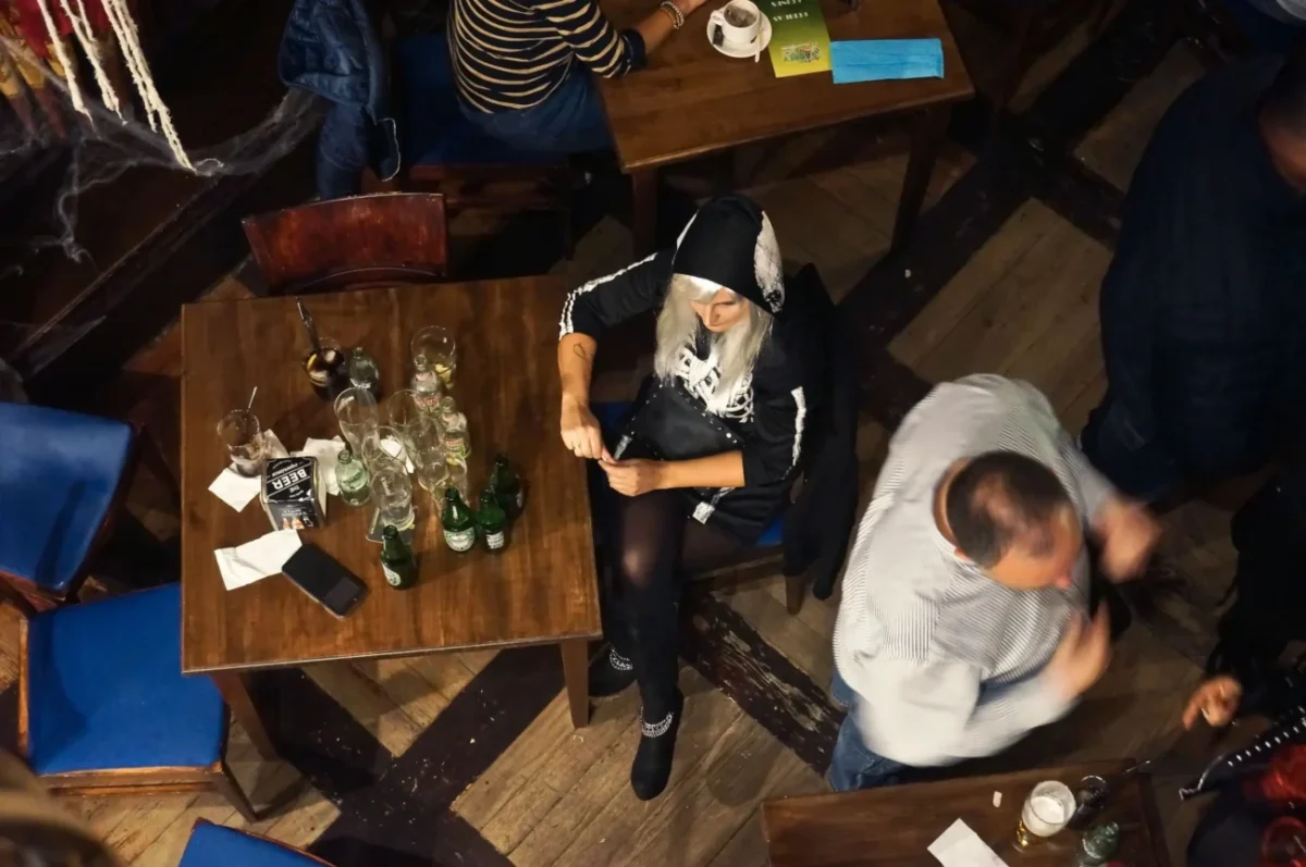 Žena sedí osamělá u stolu.