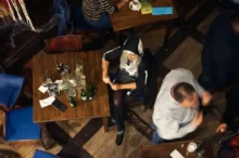 Žena sedí osamělá u stolu.