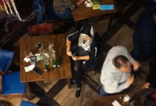 Žena sedí osamělá u stolu.