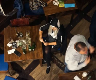 Žena sedí osamělá u stolu.