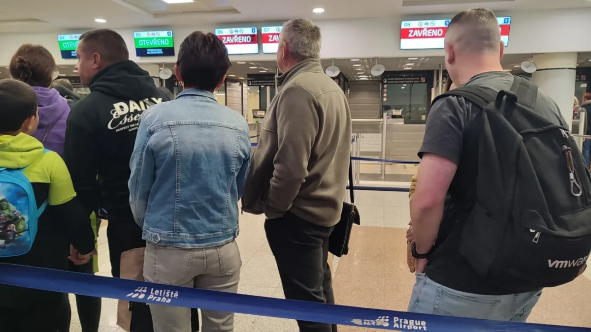 Lidé stojí ve frontě na celní kontrolu.