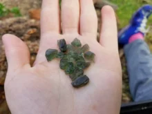 hrst surových vltavínů na dlani (detail)