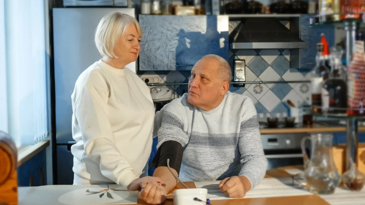 Starší žena s mužem jsou v kuchyni.