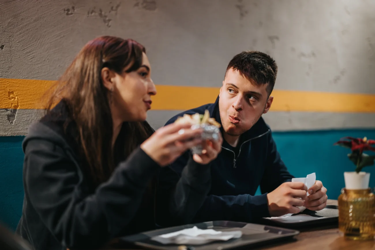 Žena s mužem si povídají v restauraci u jídla. 