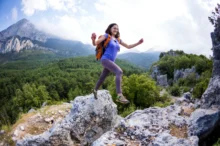 Žena skáče po horách.