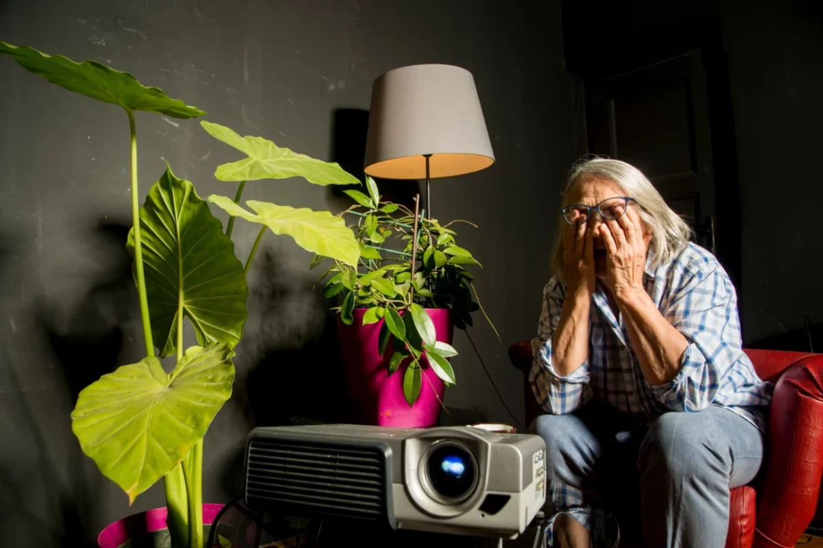 Žena sedí nešťastná mezi hromadou věcí.