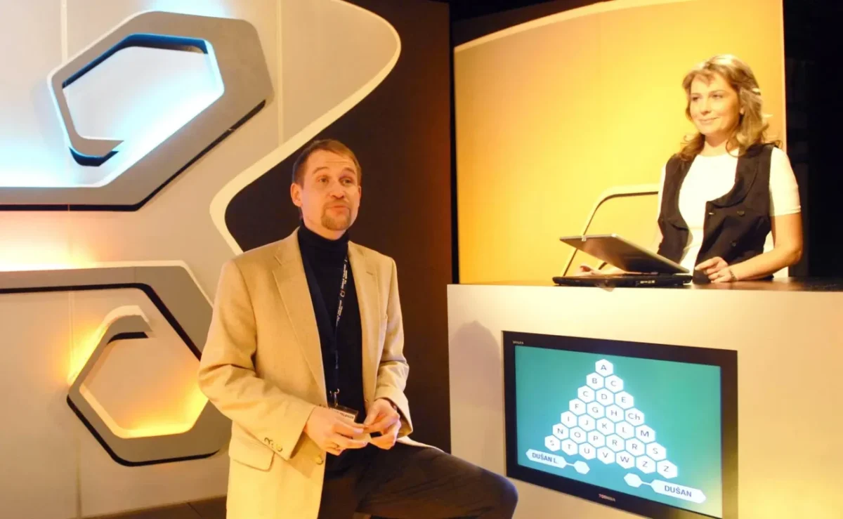 Moderátor a žena soutěžící v AZ-kvízu.