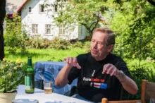 Václav Havel sedící na zahradě u stolu.