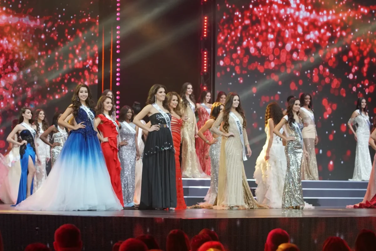 Ženy stojící na podiu během soutěže krásy.