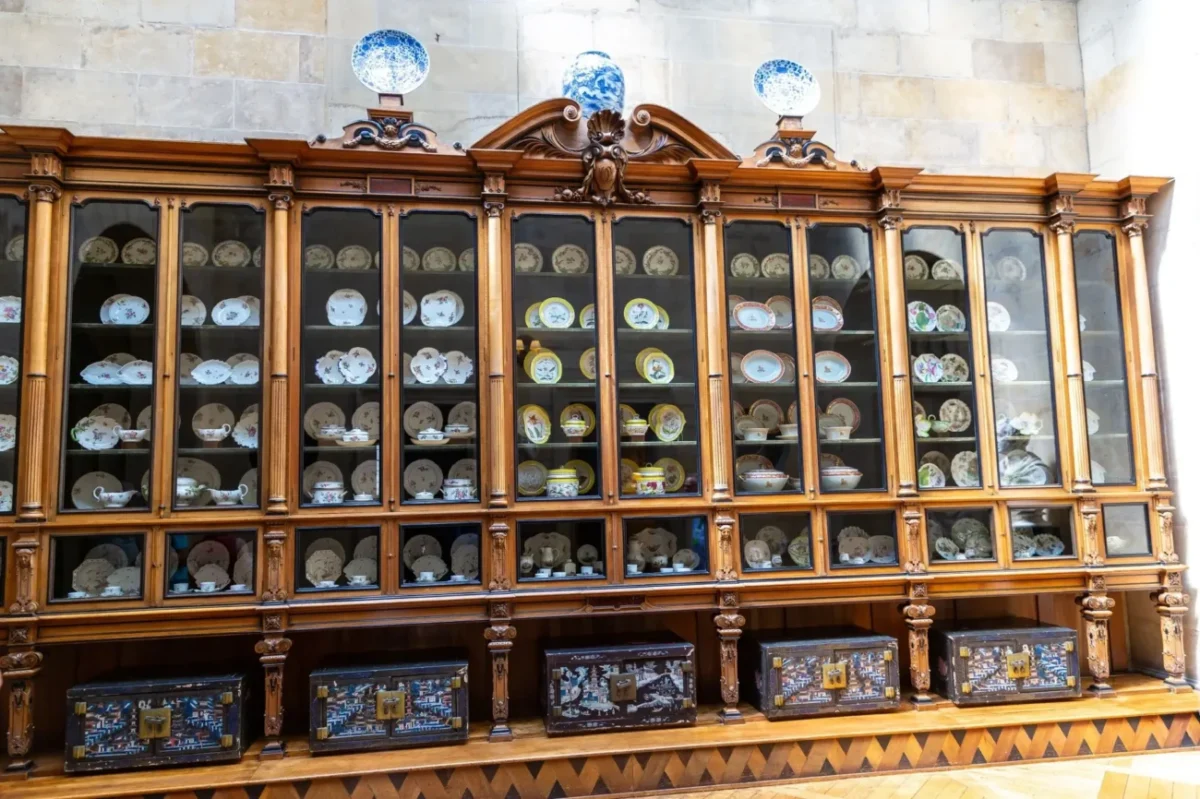 velká komoda plná starožitných talířů