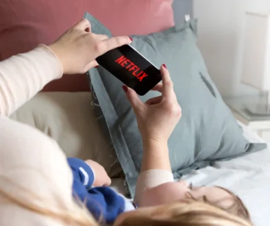 Lidé sledující Netflix v posteli.