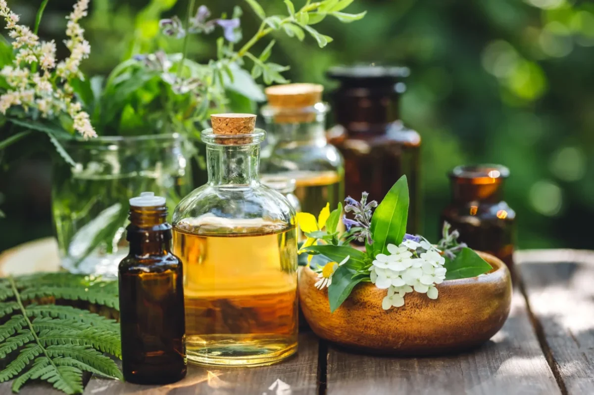 Na zahradním stole je několik bylinek a olejíčků.