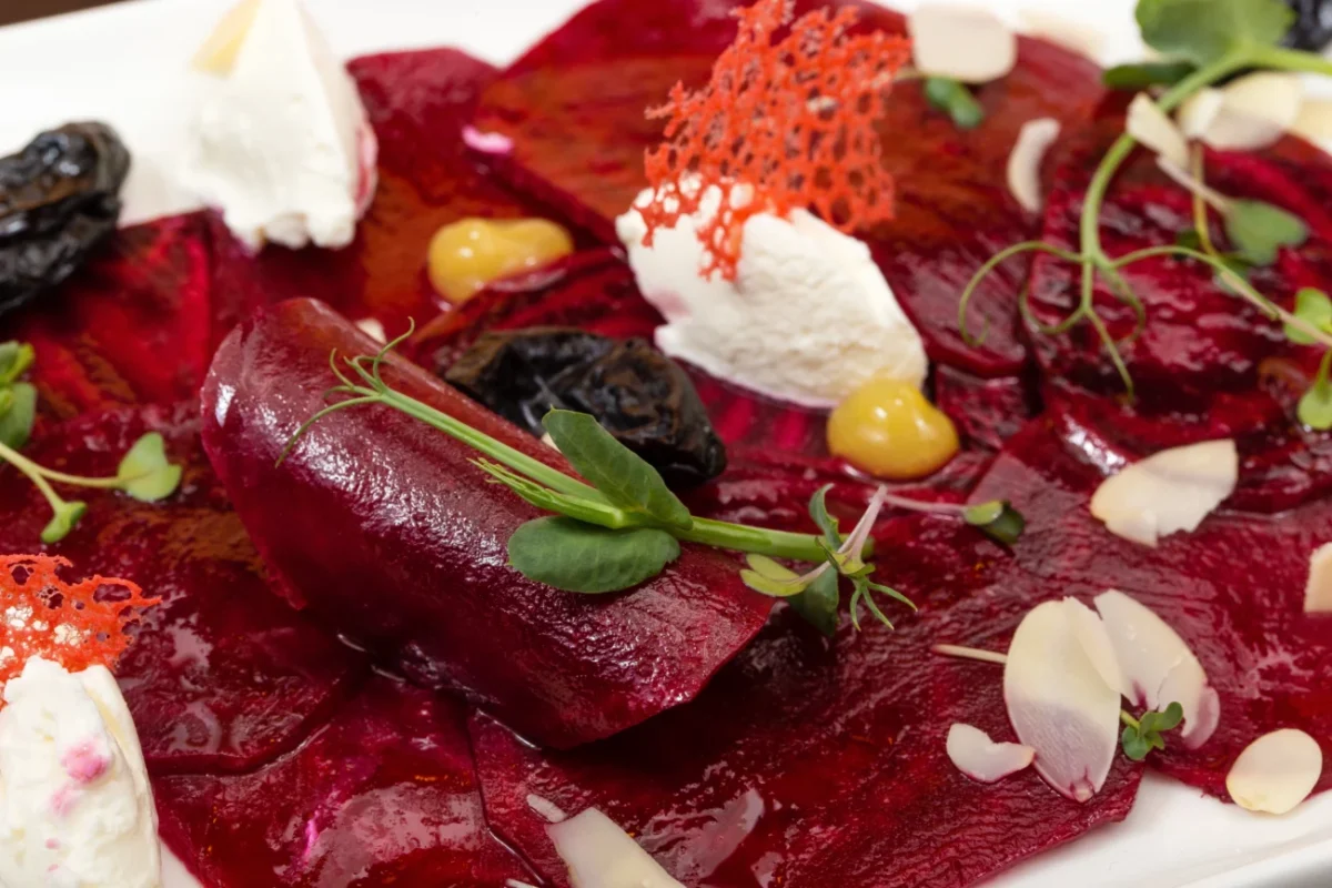 Jemné plátky červené řepy, bylinky, krémový sýr - detail luxusního pokrmu