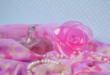 Parfém společně se skřipcem a dalšími věcmi leží na stole.