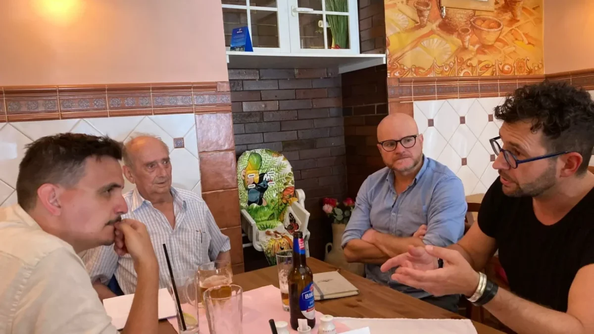 čtyři muži sedí u stolu