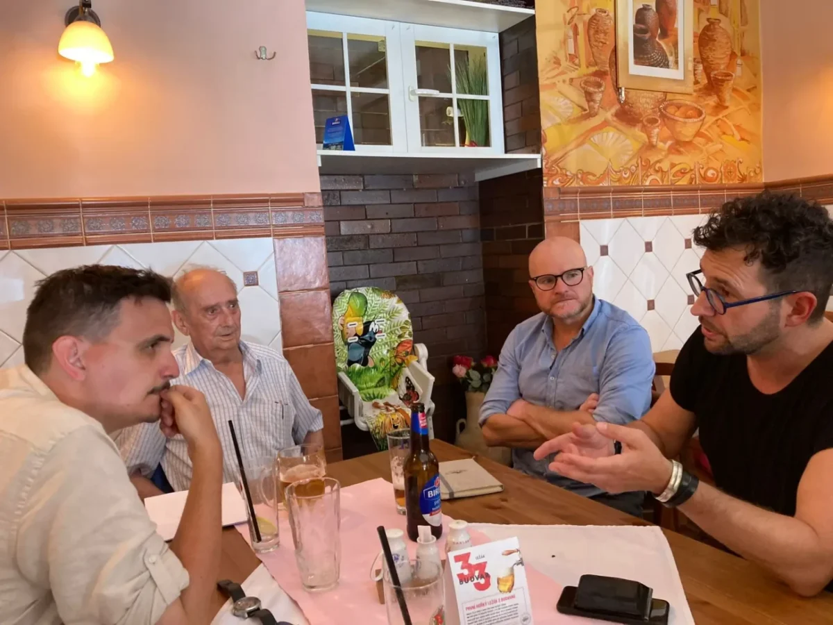 čtyři muži sedí u stolu