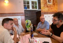čtyři muži sedí u stolu