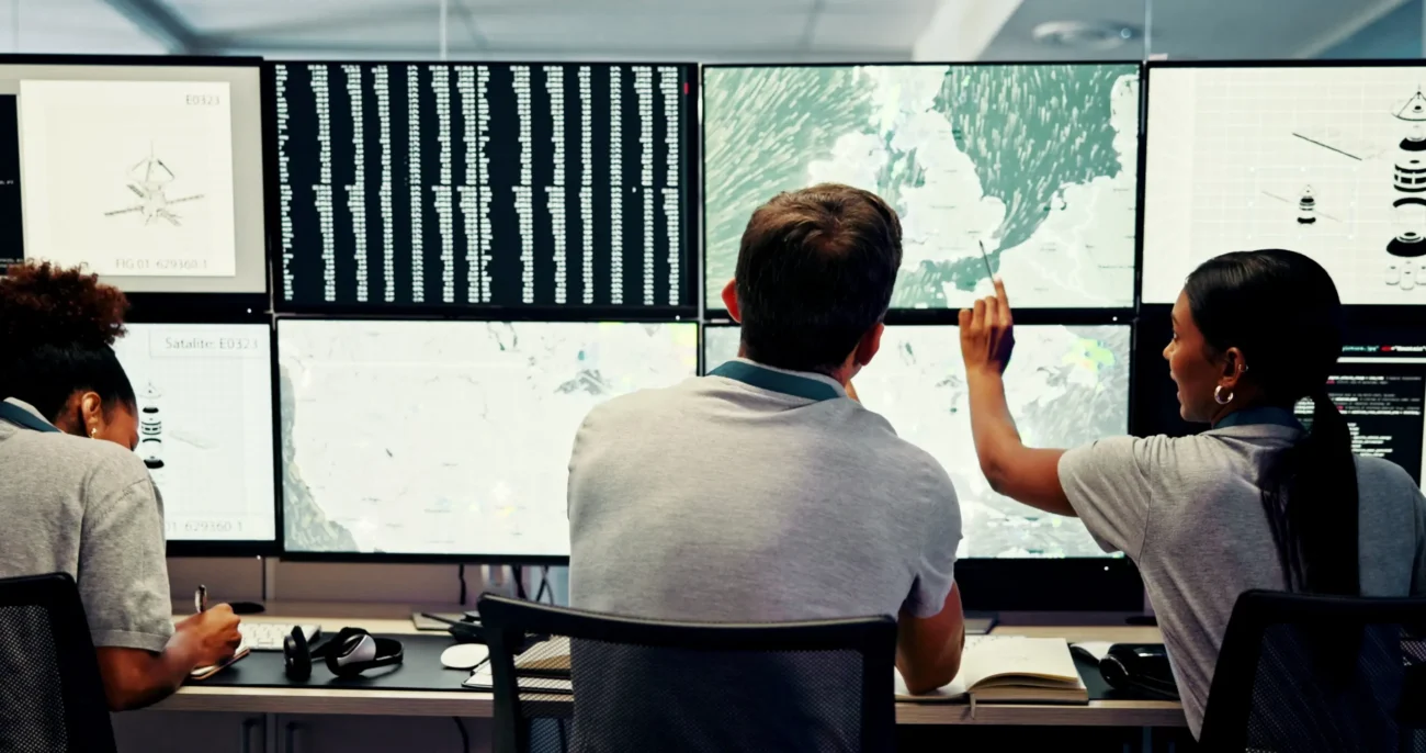shutterstock_2603323637 1 | TVGURU.cz Meteorologové zkoumají předpověď počasí na monitorech.