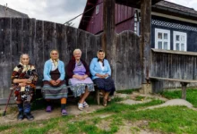Babičky sedící na lavičce ve vesnici.