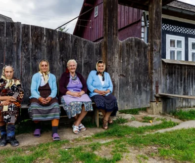 Babičky sedící na lavičce ve vesnici.