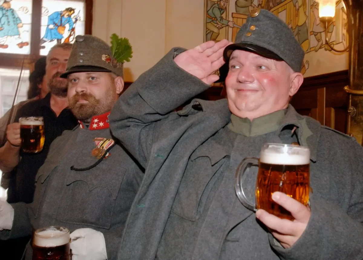 muž oblečený jako dobrý voják Švejk v hospodě