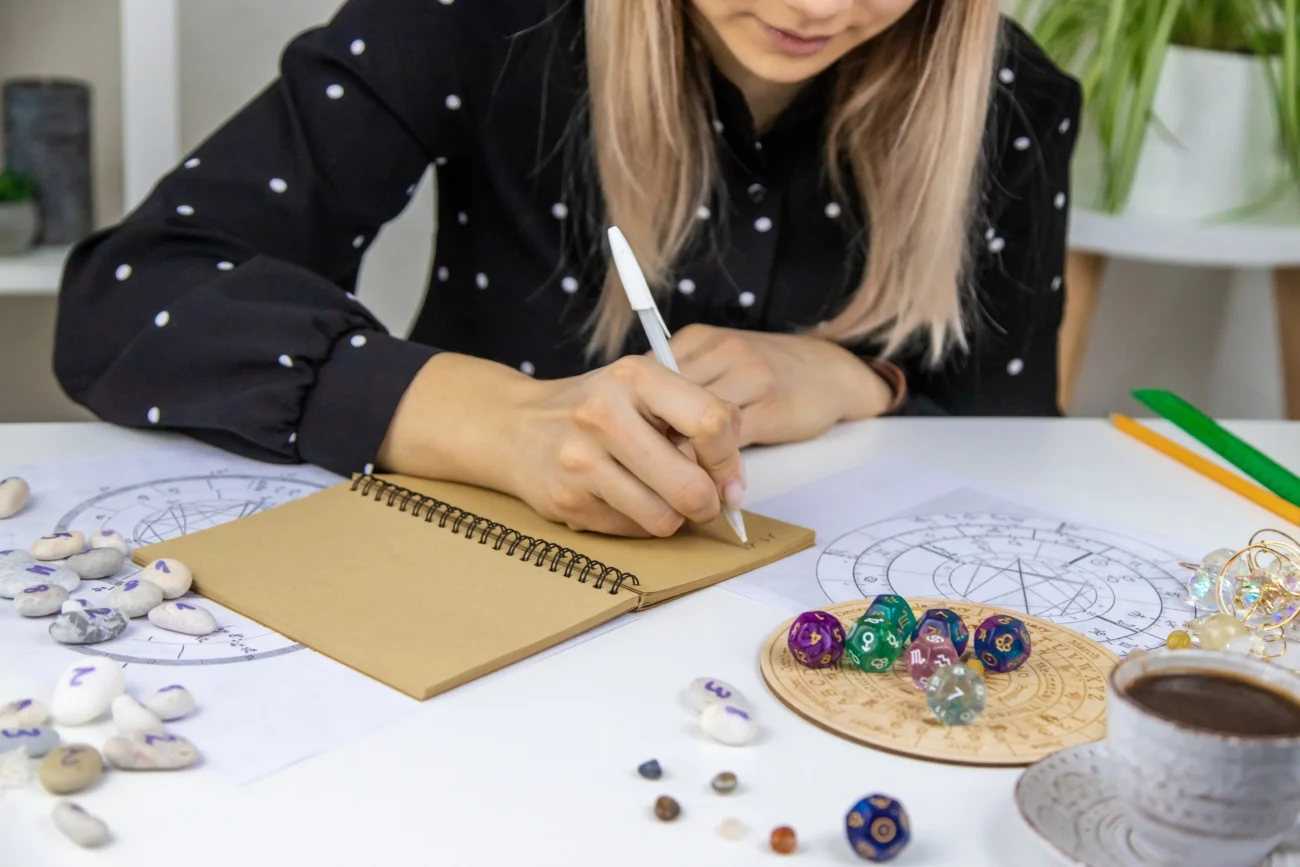 Žena píšící si informace z astrologie.