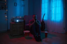 Muž ve tmě sedí na zemi.