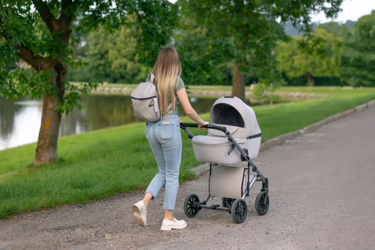 žena s kočárkem v parku