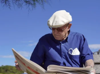 Dědeček si v parku čte noviny.