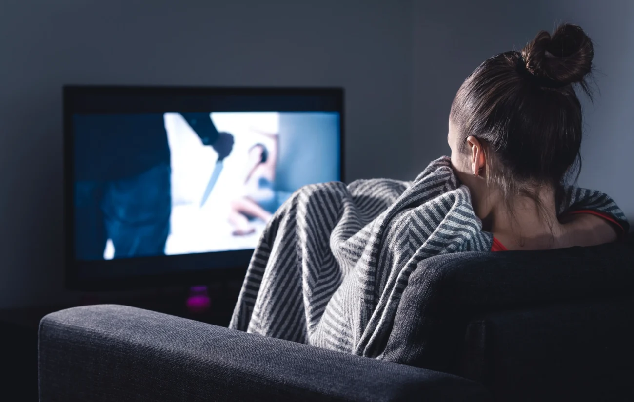 Co o vás vypoví, pokud máte rádi horory? Zdroj: Shutterstock | TVGURU.cz Žena dívající se na horor.