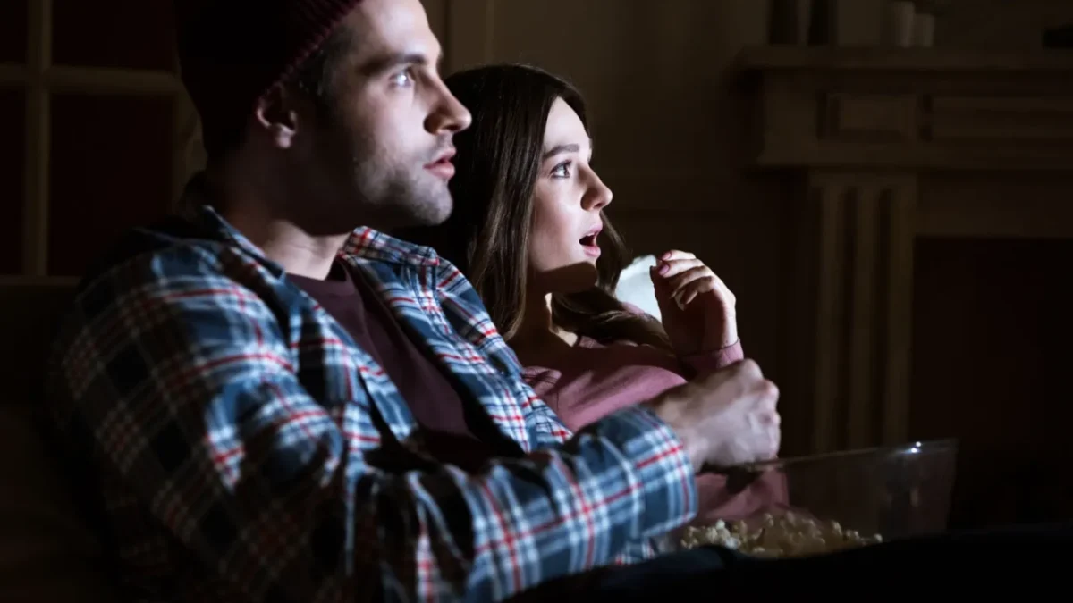 pár se dívá na film, žena je vyděšená