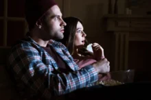 pár se dívá na film, žena je vyděšená
