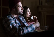 pár se dívá na film, žena je vyděšená