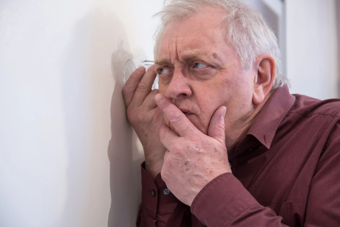 shutterstock_1690057450-2 | TVGURU.cz Muž poslouchá za zdí.