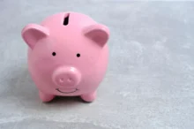 růžové prasátko na mince s úsměvem