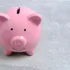 růžové prasátko na mince s úsměvem