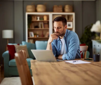Muž sedí u notebooku a přemýšlí.